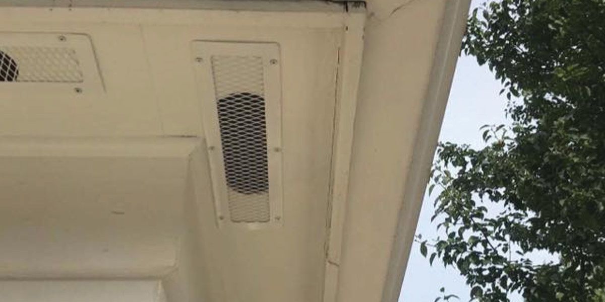 A white galvanized steel four-inch by sixteen-inch soffit vent cover installed over a soffit vent.