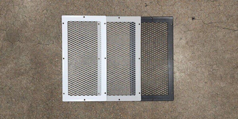 A white, gray, and black HY-GUARD EXCLUSION Soffit Vent Cover laid out on a concrete floor.