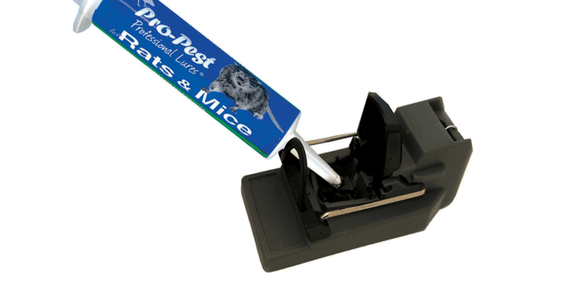 A tube of rat and mice bait being applied to a rat trap.