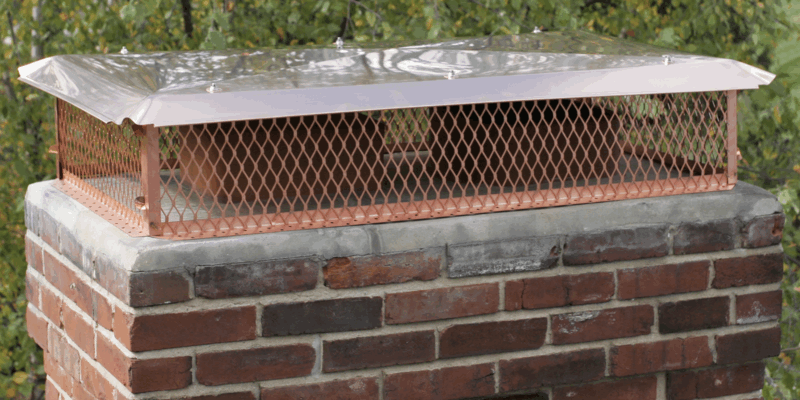 A multi-flue copper chimney cap installed on a chimney.