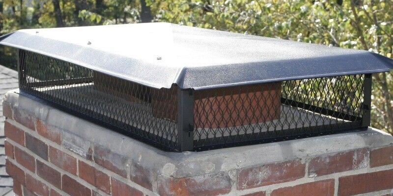 A Draft King Galvanized Steel Multi-Flue Chimney Cap installed on a chimney with multiple flues.