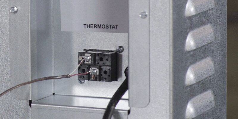 A close-up of the thermostat connection points of a Fire Chief FC1000E Wood Burning Furnace.