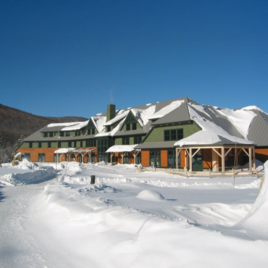 Image of the Appalachian Mountain Club Highland Lodge & Education Center in North Conway, NH covered in snow. 