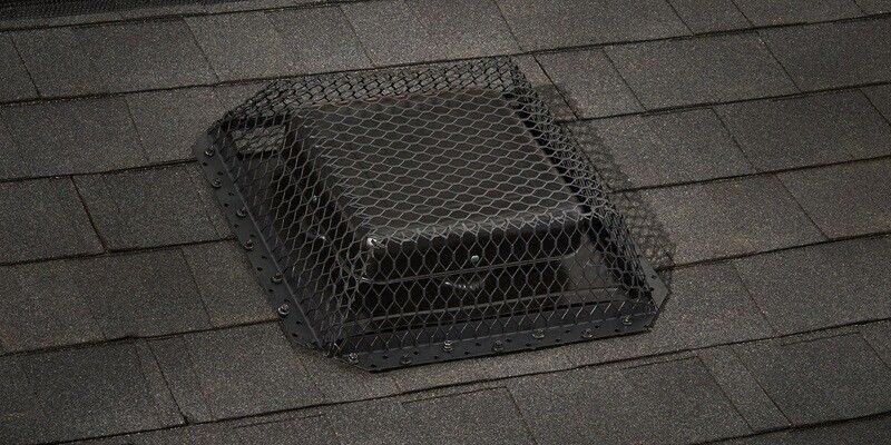 A black galvanized steel roof vent cover installed over a black roof vent with black shingles.